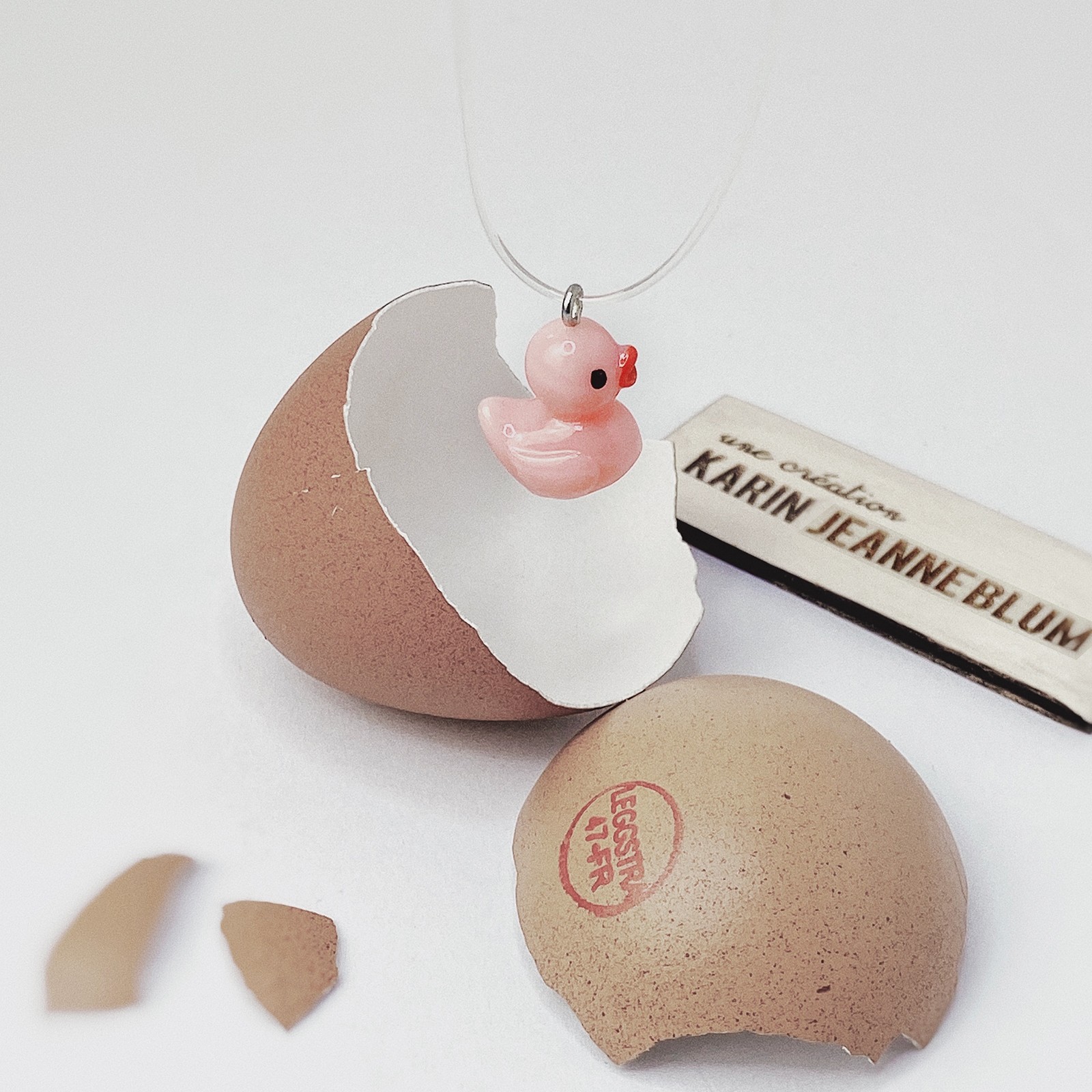 Collier canard rose caché dans un oeuf de poule cadeau insolite