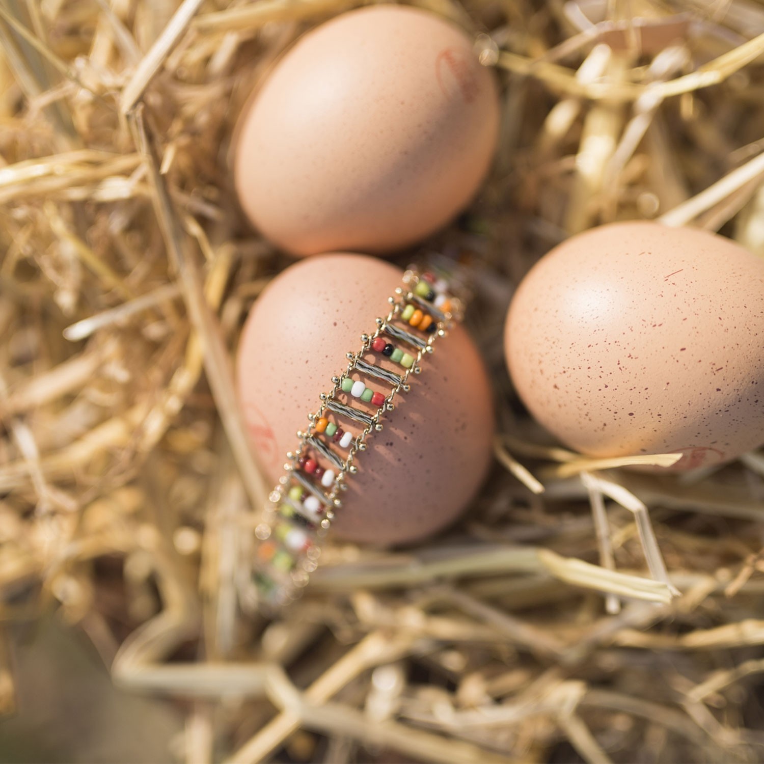 Un bracelet doré en perles de couleur caché dans un oeuf de poule - l'Eggstra